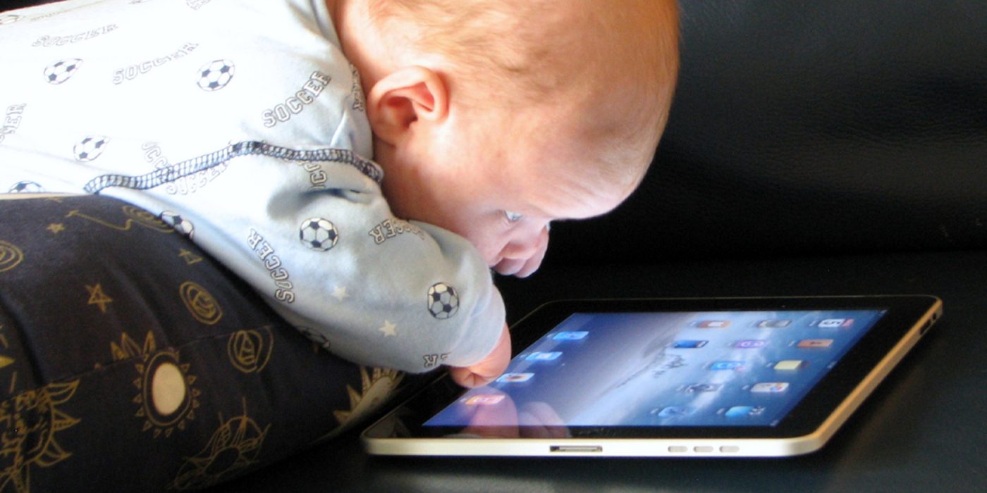 A baby peering closely at an iPad