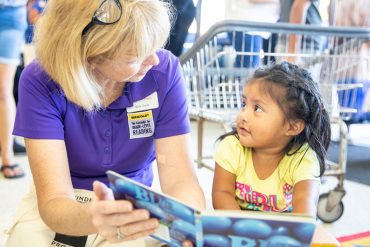 Beth Duda reads to an adorable toddler in a laundromat