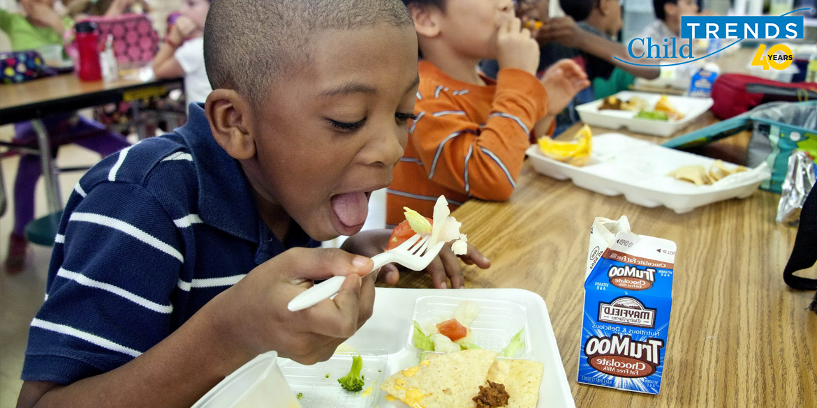 A young boy takes a bite of a school meal