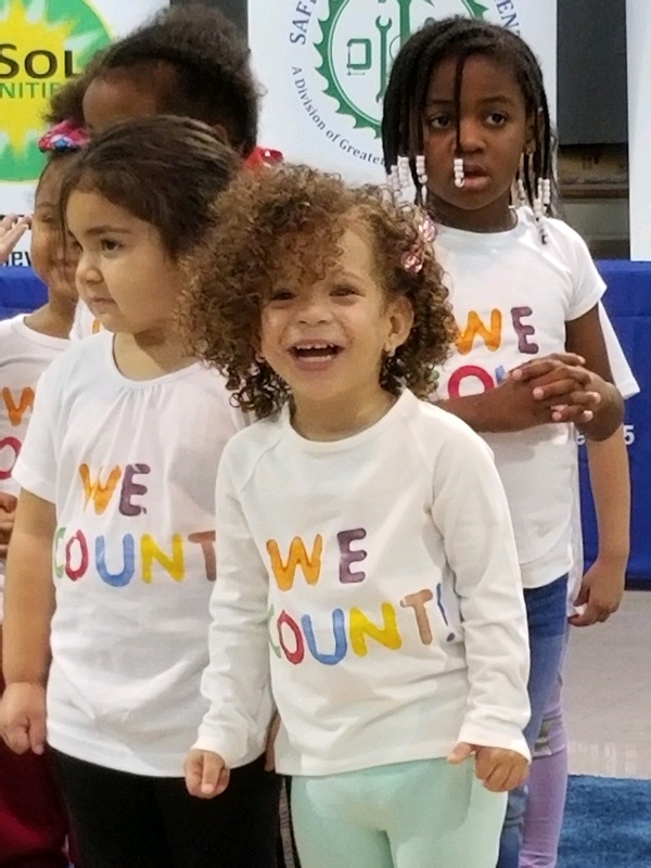 Smiling and laughing children wearing "We Count" t-shirts